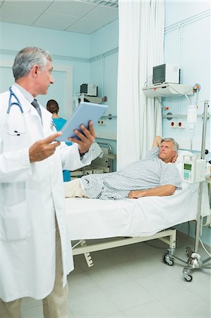 simsearch:6109-06196332,k - Patient listening to a doctor while lying in a bed Foto de stock - Sin royalties Premium, Código: 6109-06196288