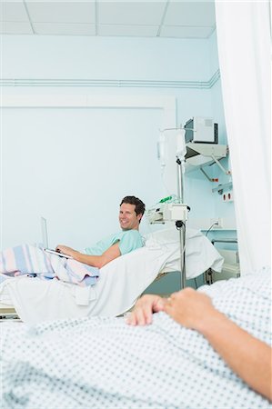simsearch:6109-06196332,k - Smiling patient in a hospital room with an other patient Foto de stock - Sin royalties Premium, Código: 6109-06196304