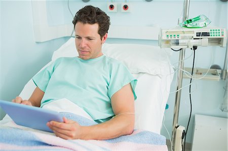simsearch:6109-06196332,k - Patient using a tactile tablet while lying on a bed Foto de stock - Sin royalties Premium, Código: 6109-06196319