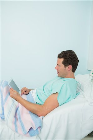 simsearch:6109-06196332,k - Patient touching a tactile tablet while lying on a bed Foto de stock - Sin royalties Premium, Código: 6109-06196332