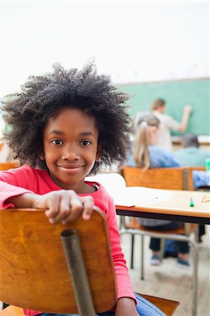 Smiling schoolgirl turned around during class Foto de stock - Sin royalties Premium, Código: 6109-06196440