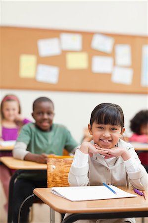 Smiling student sitting at her desk Stock Photo - Premium Royalty-Free, Code: 6109-06196505