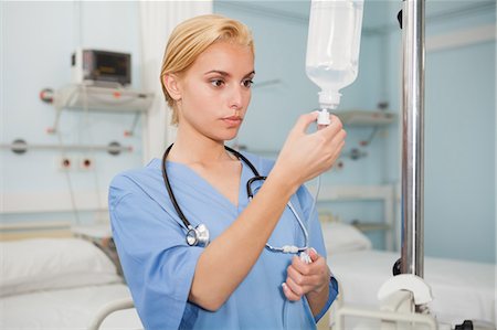 Nurse checking an intravenous drip Stock Photo - Premium Royalty-Free, Code: 6109-06684668