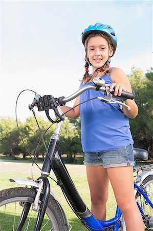 Portrait of smiling girl with her bike Stock Photo - Premium Royalty-Free, Code: 6109-06684774