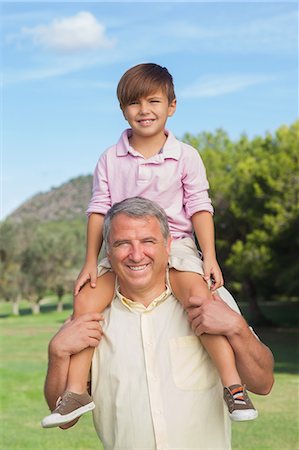 Grandfather giving grandson a piggy back Stock Photo - Premium Royalty-Free, Code: 6109-06684926