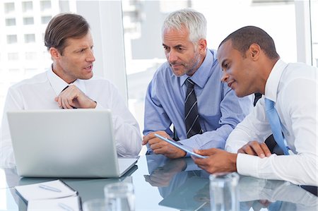 Three businessmen watching a laptop Stock Photo - Premium Royalty-Free, Code: 6109-06781387