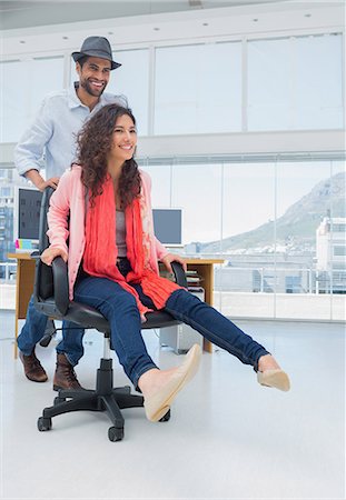 Creative business colleagues having fun on the office chair Stock Photo - Premium Royalty-Free, Code: 6109-06781513