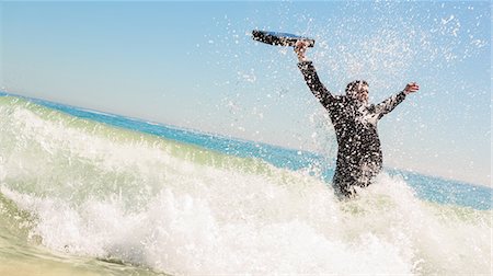 sophisticated man - Businessman raising his briefcase in the sea Stock Photo - Premium Royalty-Free, Code: 6109-06781650