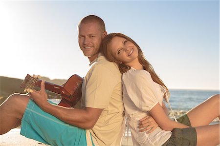 simsearch:6109-06781569,k - Cheerful couple sat back to back on the beach Stock Photo - Premium Royalty-Free, Code: 6109-06781675
