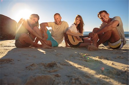 simsearch:6109-06781569,k - Group of smiling friends sitting on the beach Stock Photo - Premium Royalty-Free, Code: 6109-06781682