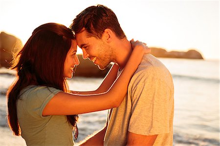 sunset couple water - Smiling couple embracing each other on the beach Stock Photo - Premium Royalty-Free, Code: 6109-06781691