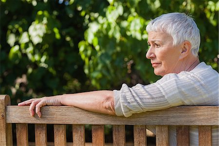 Pensive elderly woman sitting alone on a bench in a park Foto de stock - Sin royalties Premium, Código: 6109-07497002