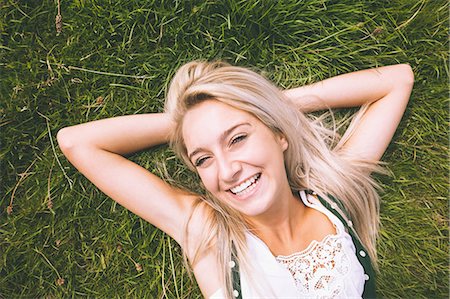 Happy gorgeous blonde lying on lawn in bright sunlight Stock Photo - Premium Royalty-Free, Code: 6109-07497119