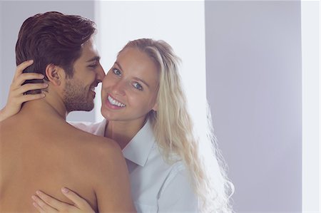 simsearch:6109-07497311,k - Young woman smiling at the camera while embracing her boyfriend Stock Photo - Premium Royalty-Free, Code: 6109-07497298