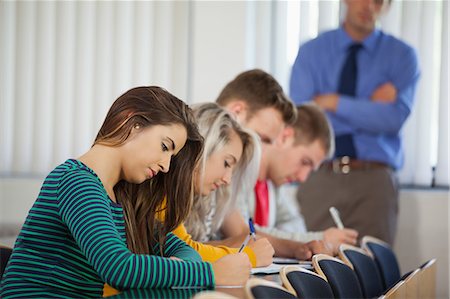 photo teacher with students in class - Serious students having an exam in classroom in a college Stock Photo - Premium Royalty-Free, Code: 6109-07497563