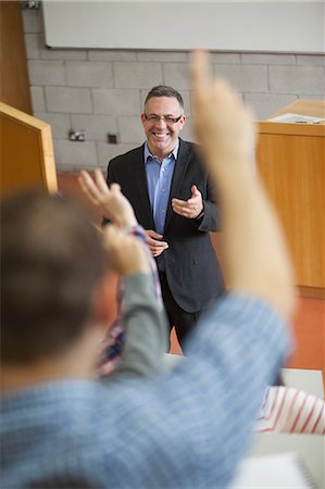 Happy lecturer pointing at student raising his hand in college Stock Photo - Premium Royalty-Free, Code: 6109-07497644