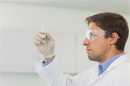 scientist - Profile view of beautiful male scientist looking at small test tube in laboratory Stock Photo - Premium Royalty-Free, Code: 6109-07497756