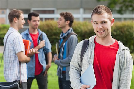 Cheerful male student smiling at camera in front of his classmates at the university Foto de stock - Sin royalties Premium, Código: 6109-07497704