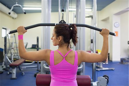 Toned woman exercising on weight machine in weights room of gym Stock Photo - Premium Royalty-Free, Code: 6109-07497869