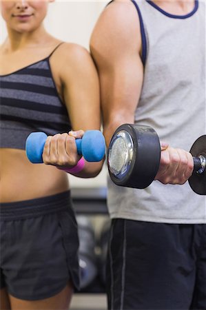 simsearch:6109-07497839,k - Attractive woman and man lifting dumbbells in weights room of gym Stock Photo - Premium Royalty-Free, Code: 6109-07497943