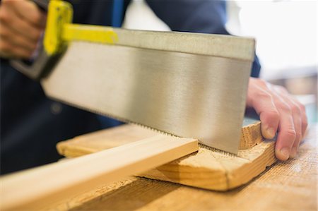 simsearch:400-07899762,k - Carpenter sawing piece of wood in workshop Stock Photo - Premium Royalty-Free, Code: 6109-07497977