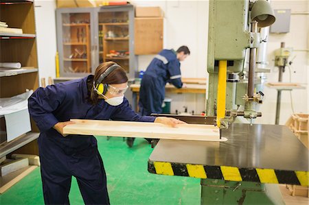 simsearch:400-07899762,k - Concentrating trainee wearing safety protection using a saw in workshop Stock Photo - Premium Royalty-Free, Code: 6109-07497997