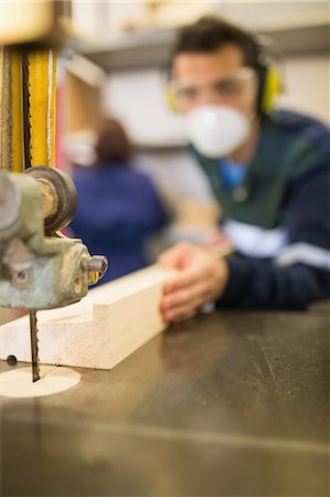 simsearch:400-07899762,k - Carpenter wearing safety protection using a saw in workshop Stock Photo - Premium Royalty-Free, Code: 6109-07497994