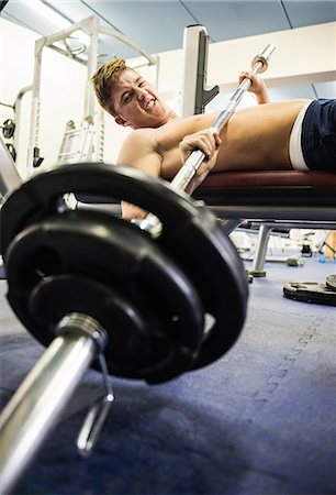 simsearch:6109-07497839,k - Grimacing man letting the barbell fall in weights room of gym Stock Photo - Premium Royalty-Free, Code: 6109-07497901