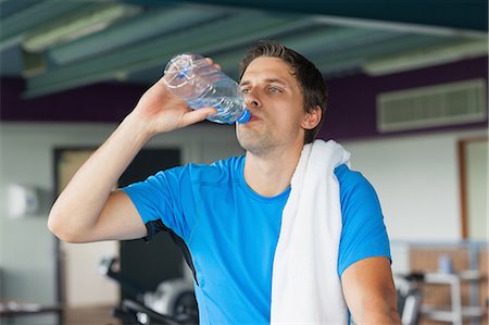 simsearch:400-04969467,k - Tired young man drinking water while working out in the gym Photographie de stock - Premium Libres de Droits, Code: 6109-07498048
