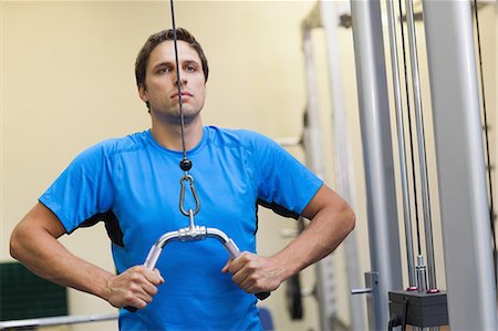 simsearch:693-08126938,k - Determined sporty young man doing exercises in the gym on lat machine Stock Photo - Premium Royalty-Free, Code: 6109-07498061