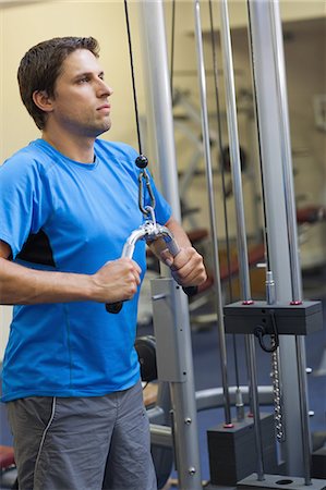 simsearch:693-08126938,k - Determined sporty young man doing exercises in the gym on lat machine Stock Photo - Premium Royalty-Free, Code: 6109-07498062