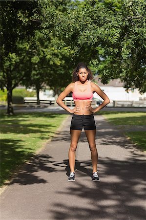 Full length portrait of a healthy young woman standing on pathway in the park Stock Photo - Premium Royalty-Free, Code: 6109-07498010