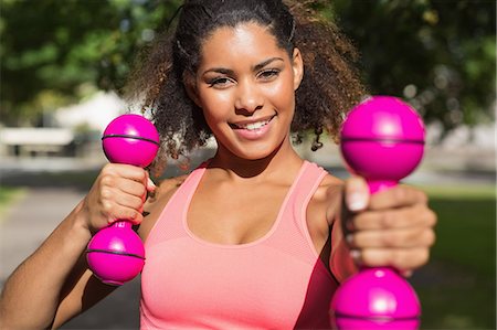 strong human physical strength - Portrait of a smiling fit young woman exercising with dumbbells in the park Stock Photo - Premium Royalty-Free, Code: 6109-07498018