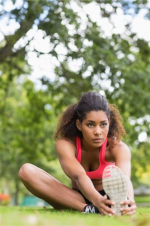 simsearch:649-04247797,k - Beautiful sporty young woman stretching her leg while sitting in the park Stock Photo - Premium Royalty-Free, Code: 6109-07498027
