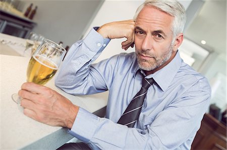 Tensed mature businessman with beer glass at bar counter Foto de stock - Sin royalties Premium, Código: 6109-07600877