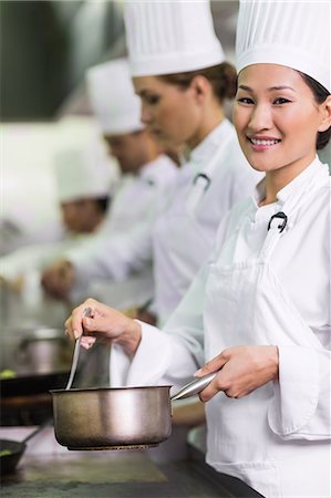 professional (pertains to sports and the arts) - Happy chef cooking at stove Stock Photo - Premium Royalty-Free, Code: 6109-07601058