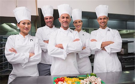 food and beverages hotel uniforms - Head chef standing with happy trainees Stock Photo - Premium Royalty-Free, Code: 6109-07601094