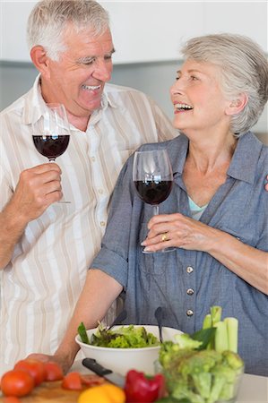 simsearch:6109-08390293,k - Smiling senior couple preparing a salad and having red wine Stock Photo - Premium Royalty-Free, Code: 6109-07601377