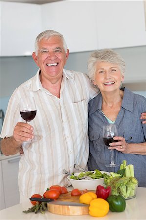 simsearch:6109-08390293,k - Smiling senior couple preparing a meal and having red wine Stock Photo - Premium Royalty-Free, Code: 6109-07601380