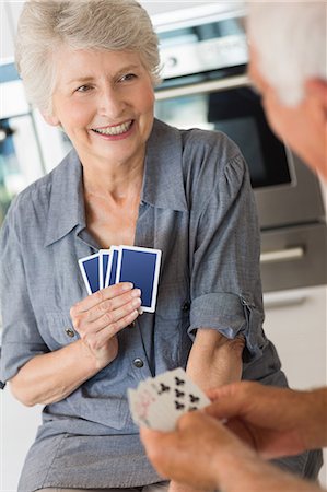 Happy senior couple playing a card game Foto de stock - Sin royalties Premium, Código: 6109-07601392