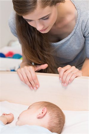 simsearch:6109-08390041,k - Happy mother watching over baby son sleeping in crib Stock Photo - Premium Royalty-Free, Code: 6109-07601311