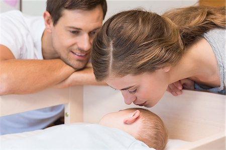 simsearch:6109-08390041,k - Happy parents watching over baby son sleeping in crib Stock Photo - Premium Royalty-Free, Code: 6109-07601312