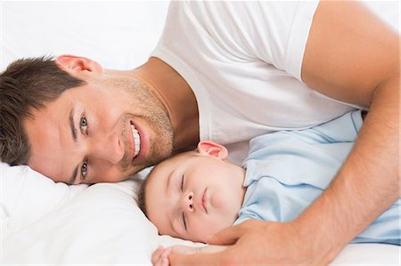 simsearch:6109-07497311,k - Happy father lying with baby son sleeping Stock Photo - Premium Royalty-Free, Code: 6109-07601317
