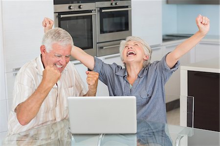 Excited senior couple using the laptop at the table Photographie de stock - Premium Libres de Droits, Code: 6109-07601411