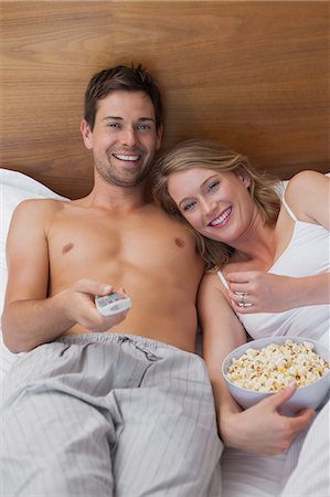 fondness - Loving relaxed young couple watching tv in bed Foto de stock - Sin royalties Premium, Código: 6109-07601538