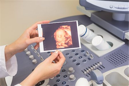 pregnant woman with doctor - Doctor showing picture Stock Photo - Premium Royalty-Free, Code: 6109-08203381