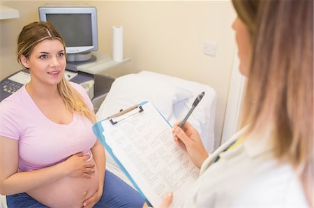 doctor examining pregnant belly - Young pregnant woman talking to her doctor Stock Photo - Premium Royalty-Free, Code: 6109-08203387