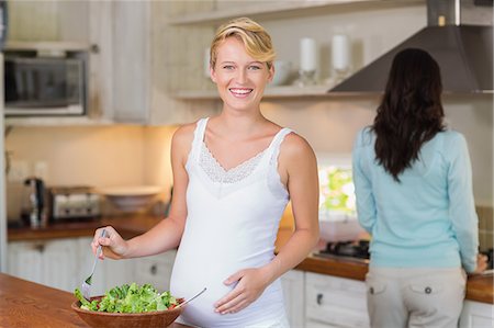 Lesbian pregnant couple preparing fresh salad Photographie de stock - Premium Libres de Droits, Code: 6109-08203412
