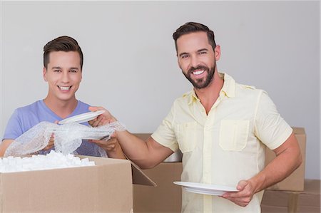 Happy homosexual couple unpacking box Stock Photo - Premium Royalty-Free, Code: 6109-08203682