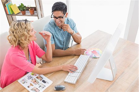 simsearch:6109-08203934,k - Smiling colleagues interacting together at desk Stock Photo - Premium Royalty-Free, Code: 6109-08203906